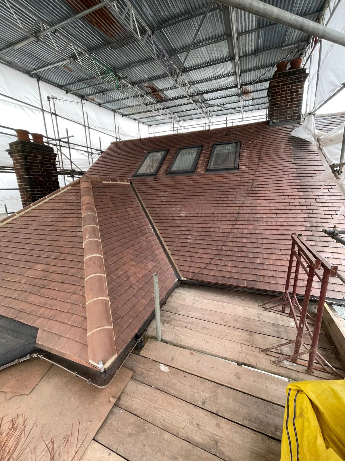 New clay tile roof installation in progress under scaffolding by M.W. Beal & Son in Essex